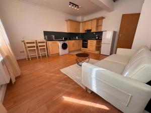 a living room with a white couch and a kitchen at Cosy 2 Story Home Leicester City Centre in Leicester