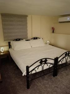 a bedroom with a large bed with white sheets at Rousan House in Um Qeis