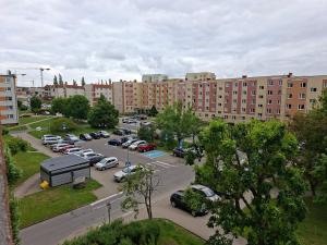 a parking lot with cars parked in front of buildings at Diwo Apartament in Koszalin