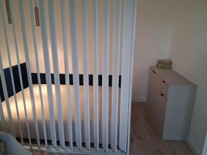 a crib in a room with a wooden floor at Diwo Apartament in Koszalin