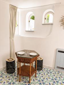 a dining room with a table and two windows at Villa Sain Charming Suite in Anacapri