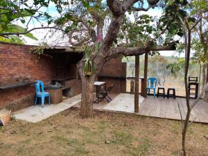 a patio with chairs and a table and a tree at sitiolosbragas in Caetanópolis