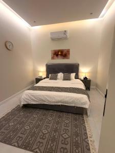 a bedroom with a large bed and a rug at أورا ل التأجير اليومي للعائلات فقط in Jeddah