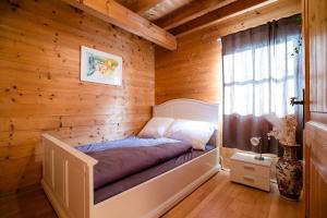 a bedroom with a bed in a wooden wall at Feel Good Place in Fritzens +1 photo