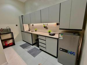 a kitchen with white cabinets and a stainless steel refrigerator at أورا ل التأجير اليومي للعائلات فقط in Jeddah