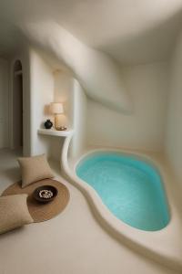 a wellness room with a swimming pool in a house at Urano Cave Suites in Santorini