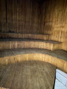 an empty wooden room with a wooden floor and benches at Skylab Accomodationz in Kasangati