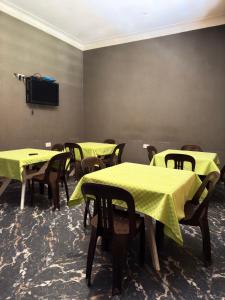 a room with tables and chairs with yellow table cloth at Skylab Accomodationz in Kasangati