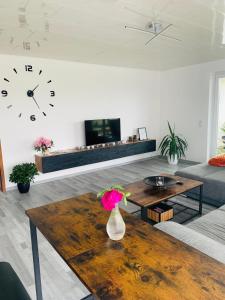 a living room with a table and a clock on the wall at Ferienidylle im Westerwald in Seck
