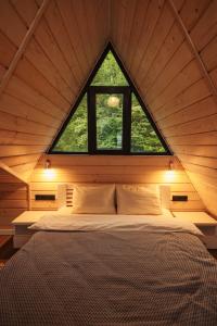 a bed in a room with a large window at Shale Maidan in Maidan Village +136 photos