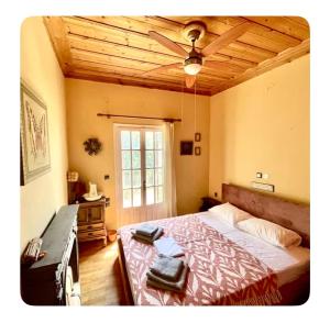 a bedroom with a bed and a ceiling fan at Ionian Lefkada Sunset House flyMeRachi40m in Exanthia
