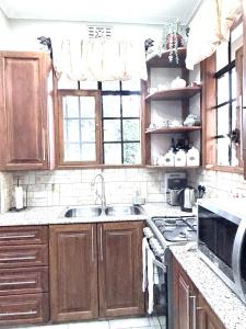 a kitchen with wooden cabinets and a stove top oven at The Angelique Oasis in Arusha