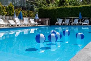 a swimming pool with blue water and white chairs at Hotel New Wave Wisła in Wisła