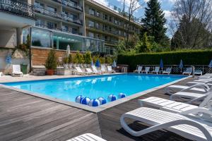 a swimming pool with lounge chairs and a hotel at Hotel New Wave Wisła in Wisła +140 photos