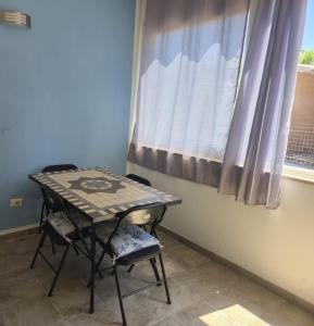 a table and two chairs in a room with a window at Sa domu nosta è un appartamento. in Castiadas
