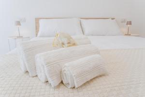 a bed with white blankets and pillows on it at Martesana47 - 5 Min S Raffaele e Linate Apt in Vimodrone