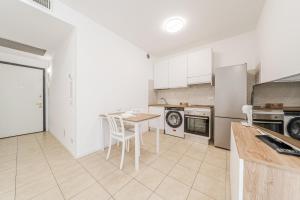 a kitchen with white cabinets and a table with chairs at Martesana47 - 5 Min S Raffaele e Linate Apt in Vimodrone +13 photos