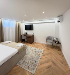 a bedroom with a bed and a desk and a television at The Elysium Rooms in Makarska