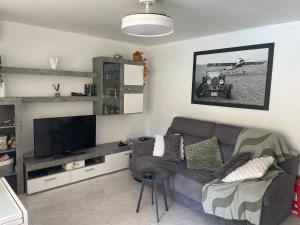 a living room with a couch and a flat screen tv at BERMUDAS-TURIS Apartamentos in Benidorm