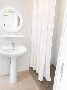a bathroom with a sink and a mirror at Camping Bucuria Bungalow in Eforie Nord