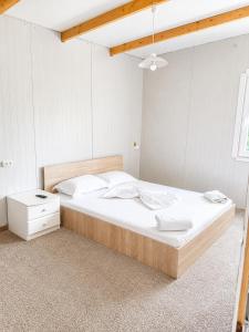 a bedroom with a large bed with white sheets at Camping Bucuria Bungalow in Eforie Nord