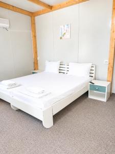 a large white bed in a room at Camping Bucuria Bungalow in Eforie Nord