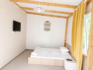 a small bedroom with a bed and a tv at Camping Bucuria Bungalow in Eforie Nord