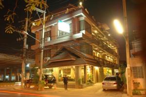 a man standing in front of a building at night at Kraisaeng Place in Phitsanulok