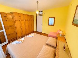 a bedroom with two beds and yellow walls at Igalo Apartment in Igalo