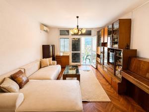 a living room with a couch and a tv at Igalo Apartment in Igalo