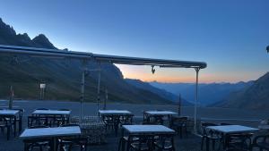 a group of tables with mountains in the background at Beau Refuge du Galibier in Le Monêtier-les-Bains