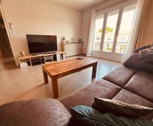 a living room with a couch and a coffee table at Belle maison hyper centrale 3 chambres in Lagord