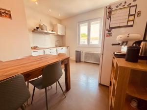 a kitchen with a wooden table and chairs at Belle maison hyper centrale 3 chambres in Lagord +17 photos