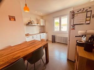 a kitchen with a wooden table and some chairs at Belle maison hyper centrale 3 chambres in Lagord
