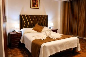a bedroom with a large bed with a large headboard at Villa Fernanda Hotel in Tacna +3 photos