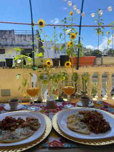 two plates of food on a table with wine glasses at La casita de Adri habitación privada en alojamiento compartido en zona colonial in Santo Domingo