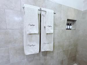 a bathroom with white towels hanging on a shower at The Angelique Oasis in Arusha +19 photos