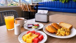 a table with two plates of food and a glass of orange juice at Vadamar Hotel Collection Rodadero in Gaira