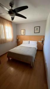 a bedroom with a large bed with a ceiling fan at Casa la Paloma in Es Caló +24 photos