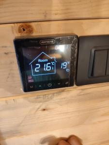 eine Person, die ein Handy mit einer Uhranzeige in der Hand hält in der Unterkunft Villa Viktor Šipovo in Šipovo