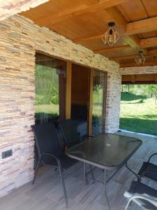 eine überdachte Veranda mit Tisch und Stühlen in der Unterkunft Villa Viktor Šipovo in Šipovo