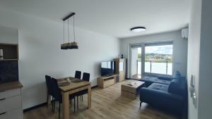 a living room with a blue couch and a table at Ceramic Studio Bolesławiec-klimatyzacja, parking podziemny in Bolesławiec
