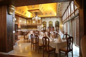 a dining room with tables and chairs and a chandelier at Le Royal Amman in Amman