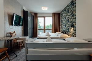 a bedroom with two beds and a table and a window at Penzión Topky in Banská Štiavnica +92 photos