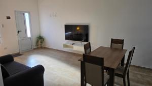 a dining room with a table and a television on a wall at Moderno apartamento en Colón in Colón Buenos Aires Province