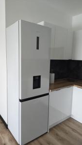 a kitchen with white cabinets and a refrigerator at Ceramic Studio Bolesławiec-klimatyzacja, parking podziemny in Bolesławiec +5 photos