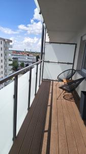 a balcony with two chairs and a view of a city at Ceramic Studio Bolesławiec-klimatyzacja, parking podziemny in Bolesławiec