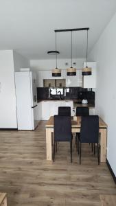 a kitchen and dining room with a table and chairs at Ceramic Studio Bolesławiec-klimatyzacja, parking podziemny in Bolesławiec