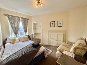 a bedroom with a bed and a couch and a window at The Castle Front Nest in Inverness