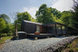 a small black house on a gravel yard at Shale Maidan in Maidan Village